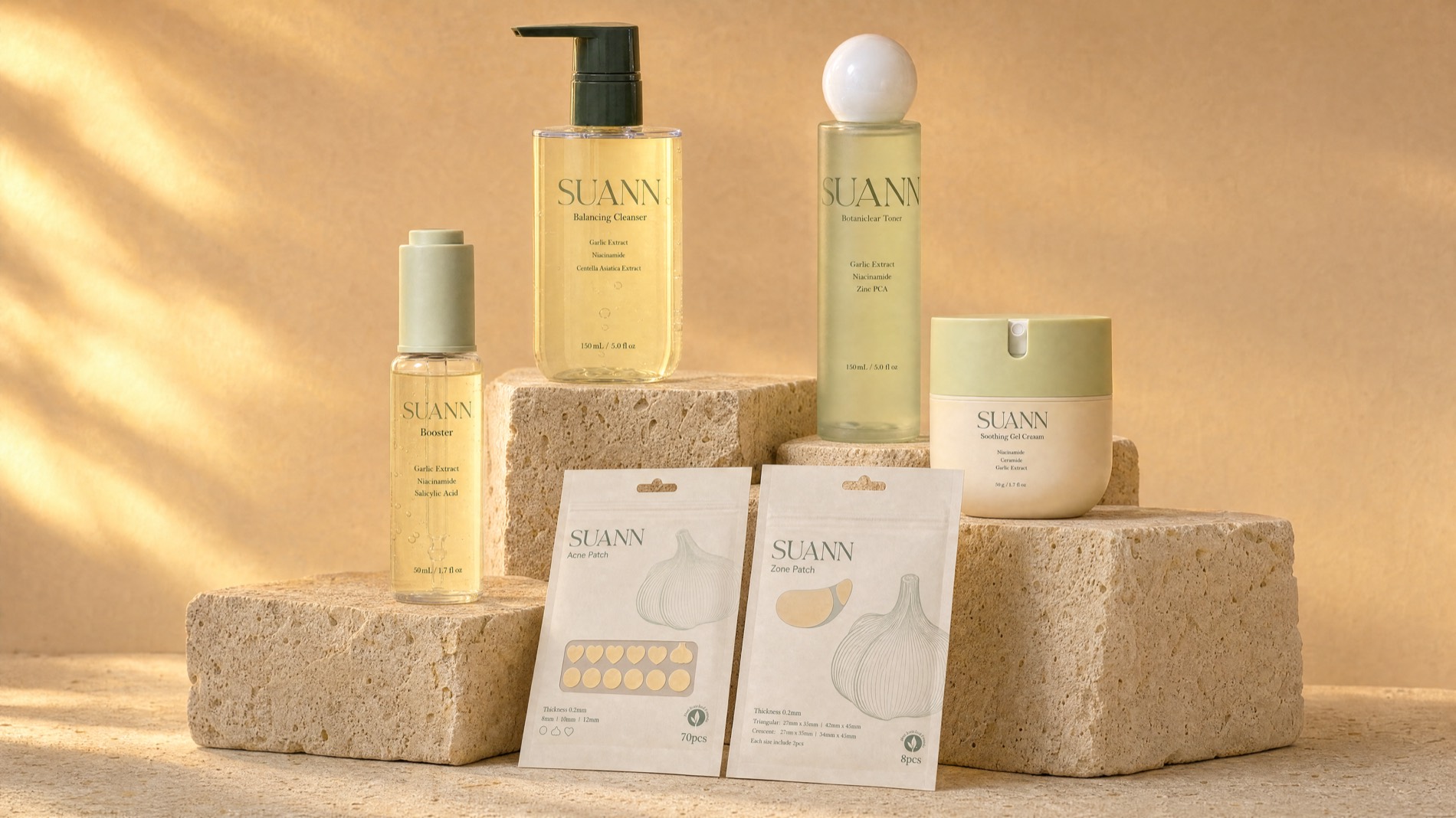 The full SUANN collection — cleanser, toner, booster, gel cream and patches — on stone pedestals